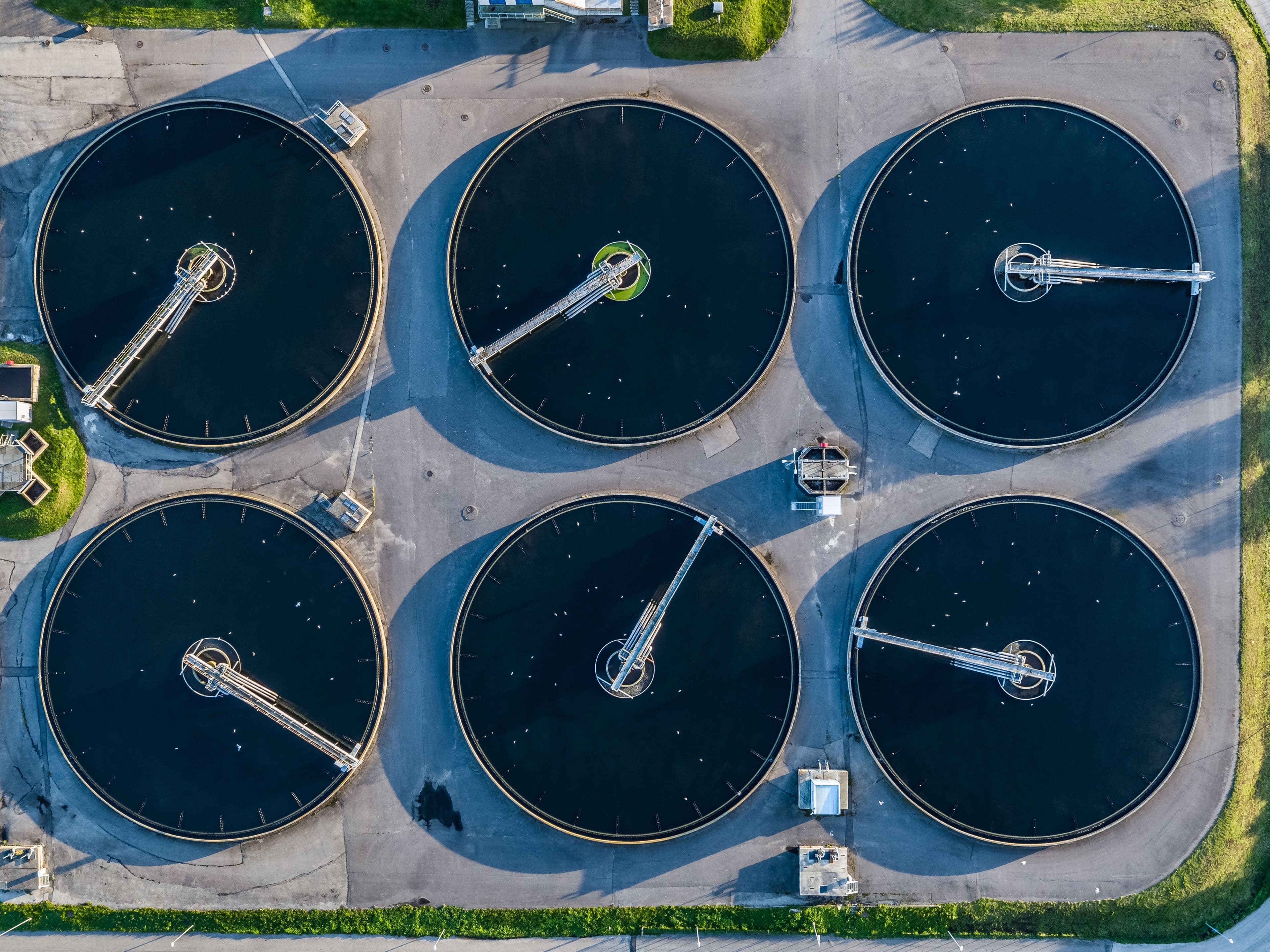 Pildil on kuus suurt ümmargust setitite basseini, mis paiknevad kahes reas tööstuslikul platsil. Basseinid on tumeda veepinnaga ja igaühes on keskel metallist segamismehhanism,.